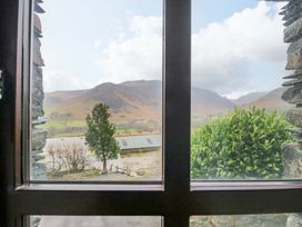 A view of mountains and trees from a window at Newlands Fell Cottage in Newlands near Keswick