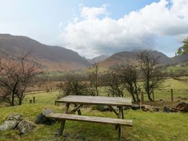 A picnic table overlooking mountains and fields at Newlands Fell Cottage Newlands near Keswick