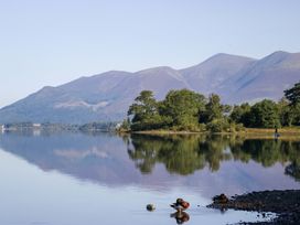 A lake with mountains in the background and trees along the shore at Newlands Fell Cottage, Newlands near Keswick