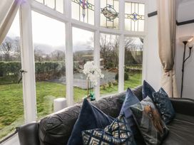 A living room with a view through a large window at Herdwick Croft in Bassenthwaite