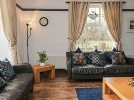 A living room with a sofa and lamp at Herdwick Croft in Bassenthwaite