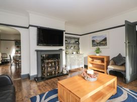 A living room with a television and fireplace at Herdwick Croft in Bassenthwaite