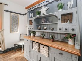 A cabinet with shelves and decorative items at Herdwick Croft in Bassenthwaite