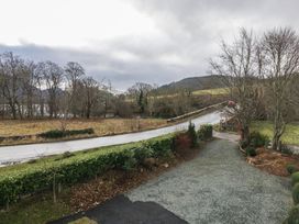 A view of a road with trees and mountains at Herdwick Croft in Bassenthwaite