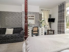 A bedroom with a four-poster bed and a sofa at Herdwick Croft in Bassenthwaite