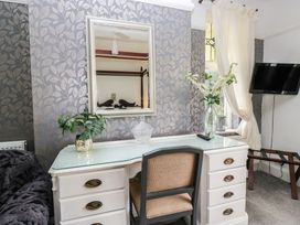 A bedroom with a desk and mirror at Herdwick Croft in Bassenthwaite