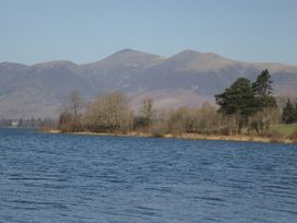 A lake with mountains and trees at Herdwick Croft in Bassenthwaite