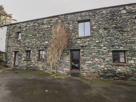 A stone building with windows and a front door at Newlands Cottage in Keswick