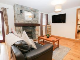 A living room with a fireplace and sofa at Newlands Cottage in Keswick