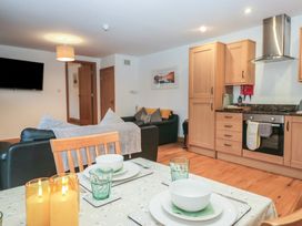 A living room with a kitchen area and dining table at Newlands Cottage Keswick
