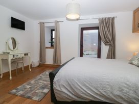 A bedroom with a bed and mirror at Newlands Cottage in Keswick