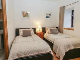 A bedroom with two beds and a lamp at Newlands Cottage in Keswick