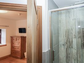 A bathroom with a shower and chest of drawers at Newlands Cottage in Keswick