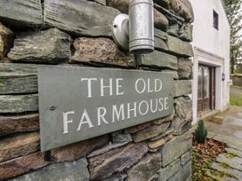 A sign on a stone wall at The Old Farmhouse in Cockermouth