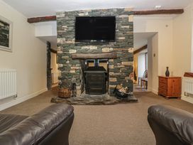 A living room with a fireplace and television at Birkbank Farm in Cockermouth
