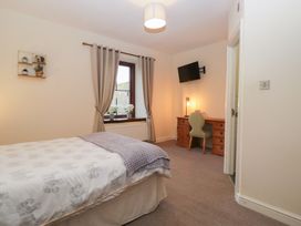 A bedroom with a bed and desk at Birkbank Farm in Cockermouth