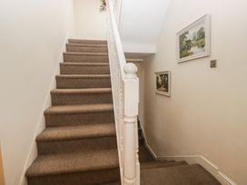 A staircase with carpet and wall paintings at Birkbank Farm in Cockermouth