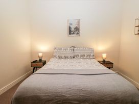 A bedroom with a bed and nightstands at Birkbank Farm in Cockermouth