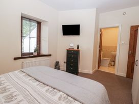 A bedroom with a bed and television at Birkbank Farm in Cockermouth