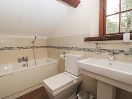 A bathroom with a bathtub, toilet, and sink at Birkbank Farm in Cockermouth