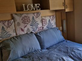 A bedroom with a bed and decorative pillows at Red Lion Caravan Park