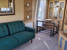 A dining room with a sofa and table at Red Lion Caravan Park