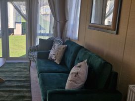 A living room with a sofa and armchair at Red Lion Caravan Park in Arbroath