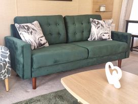 A sofa with cushions and a coffee table at Red Lion Caravan Park Arbroath