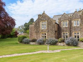 An outdoor view of a stone building with garden at Dowrich West Wing Apartment in Crediton