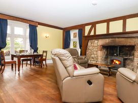 A living room with armchairs and a dining table at Dowrich West Wing Apartment in Crediton