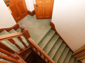 A staircase with wooden handrail and doors at Dowrich West Wing Apartment in Crediton