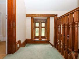 A hallway with a wooden railing and window at Dowrich West Wing Apartment Crediton
