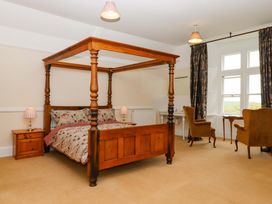 A bedroom with a four-poster bed and chairs at Dowrich West Wing Apartment in Crediton