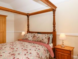A bedroom with a four-poster bed and bedside table at Dowrich West Wing Apartment in Crediton