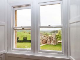 View from a window showing a stone wall and grass at Dowrich West Wing Apartment in Crediton