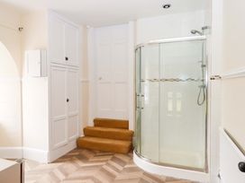 A bathroom with a shower and cupboards at Dowrich West Wing Apartment in Crediton