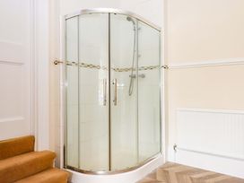 A shower enclosure with a glass door in the bathroom at Dowrich West Wing Apartment in Crediton