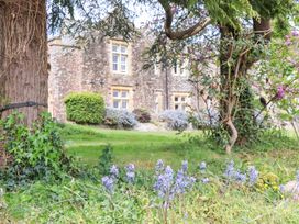 An outdoor area with flowers and a building in the background at Dowrich West Wing Apartment in Crediton