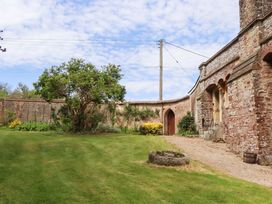 A garden with a tree and pathway at Dowrich West Wing Apartment in Crediton