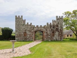 A stone gate with turrets and a pathway at Dowrich West Wing Apartment in Crediton