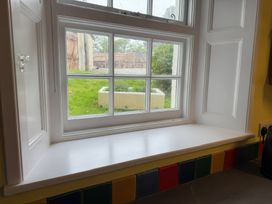 A kitchen window with a view of a grassy area at Dowrich West Wing Apartment near Sandford, Devon