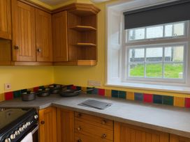 A kitchen with wood cabinets and cooking pots at Dowrich West Wing Apartment near Sandford, Devon