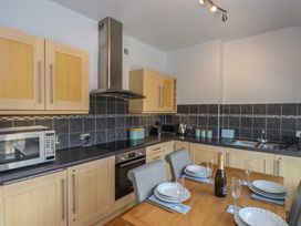 A kitchen with cabinets and appliances at Flat 1