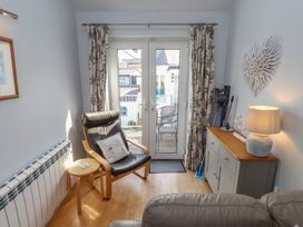 A living room with an armchair and door leading to the outside at Flat 1