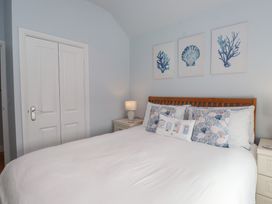 A bedroom with a bed and artwork on the wall at Flat 1 