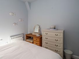 A bedroom with a bed, dresser, and mirror at Flat 1