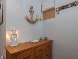 A hallway with a lighthouse lamp and wooden anchor at Flat 1