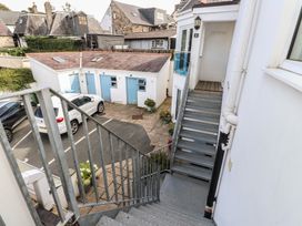 A staircase overlooking an outdoor area with garages and parked cars at Flat 1