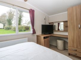 A bedroom with a desk and television at 49 Cader Idris, Hafan-Y-Mor Holiday Park Pwllheli