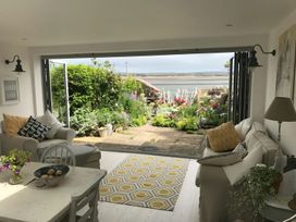 A living room with a sofa and table overlooking a garden at Mariners Cottage in Bideford
